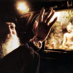 Osho waving past Buddha statue