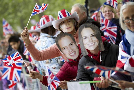People watching the wedding parade with flags