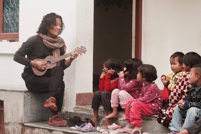 Manose playing music to children