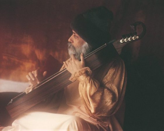 Osho playing an instrument