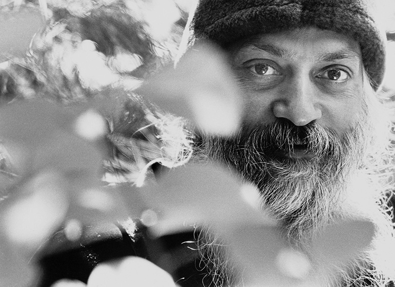 Osho behind plants