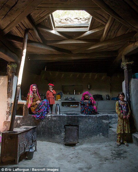 Afghan family inside their traditional Pamiri house