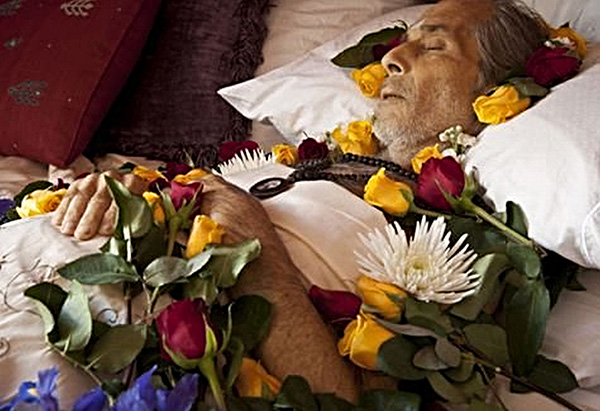 dead man surrounded by flowers