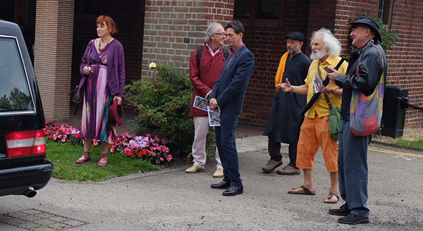 friends waiting for the coffin to be unloaded