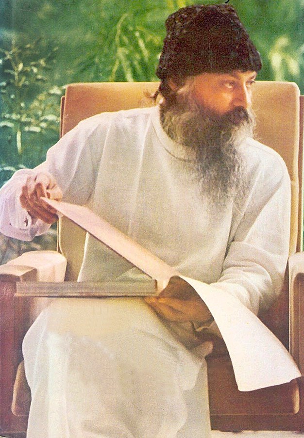 Osho with book in garden