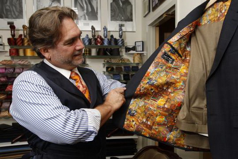 tailor looking at the inside of a coat