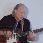 Deva singing and playing the guitar