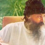 Osho in garden holding a book