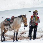 man with horse in the snow