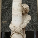 Sculpture of man holding a pillar