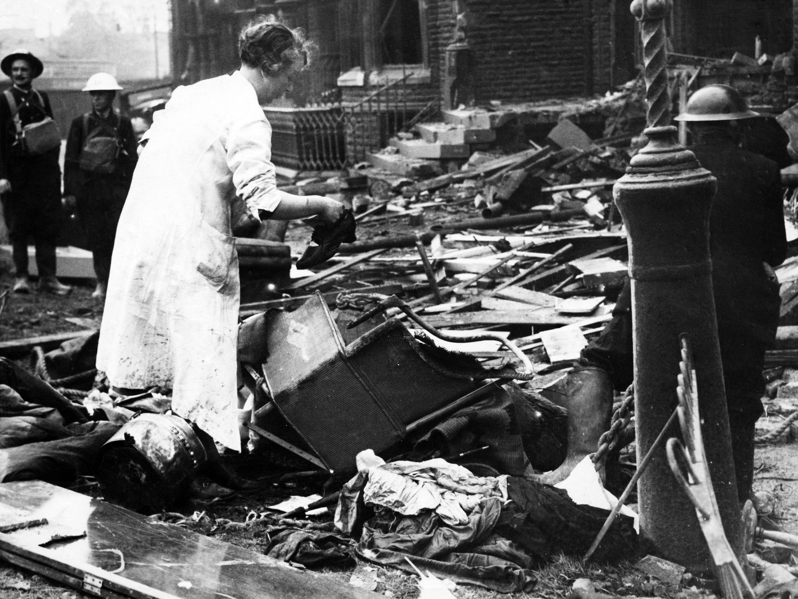Bomb damage in Liverpool during the Second World War. A woman searches the wreckage of her home for belongings, after a German raider had dropped bombs on it during a raid to a block of flats in Belvidere Road, Liverpool. 27th September 1940.