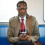Man in train with cellphone